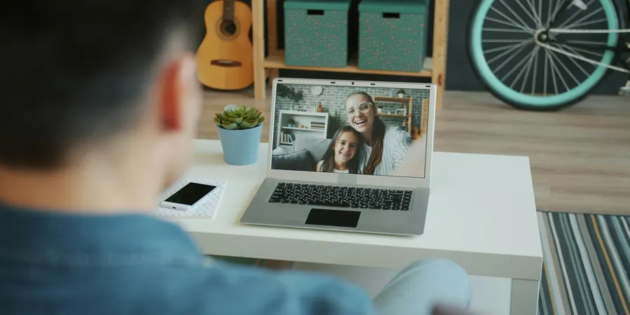 Pai em videochamada com a esposa e a filha, família com filho cardiopata nos Estados Unidos