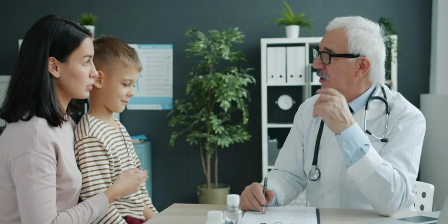 Mãe e filho em consulta com o médico, quando levar a criança ao cardiologista