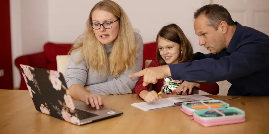 Pais e filha revisando documentos no notebook, segunda opinião com cardiopediatra