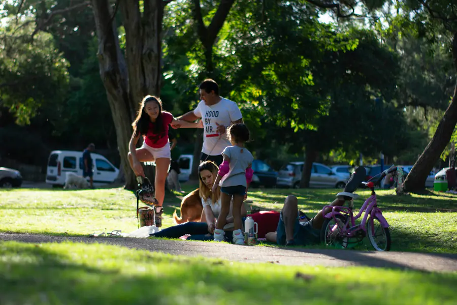 Família com crianças em piquenique e brincadeiras no parque, hábito que reduz a obesidade infantil e o risco cardiovascular